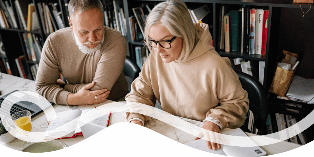 Two people reviewing documents in a library.