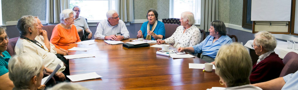 Residents sit around conference table