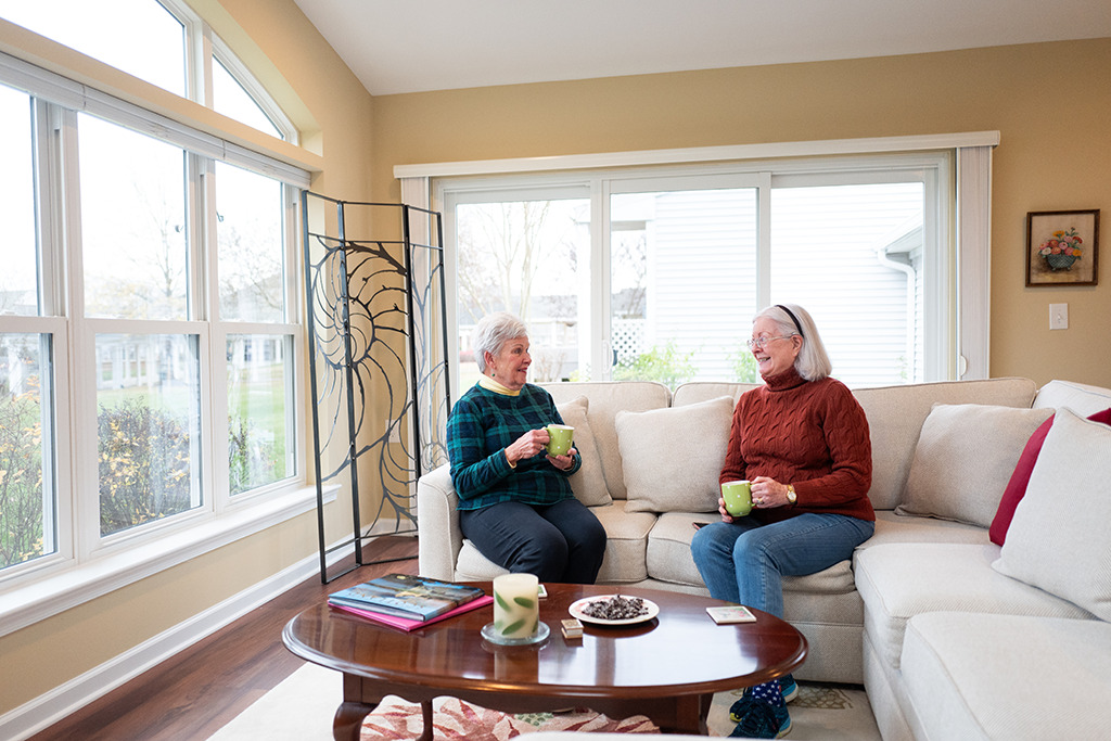 two resident women chatting in sunroom