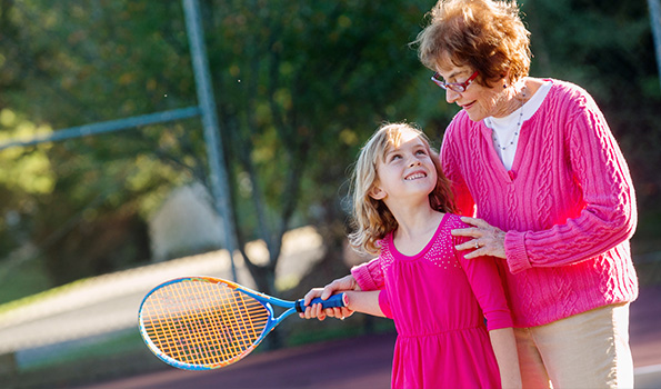 resident with child playing pickleball