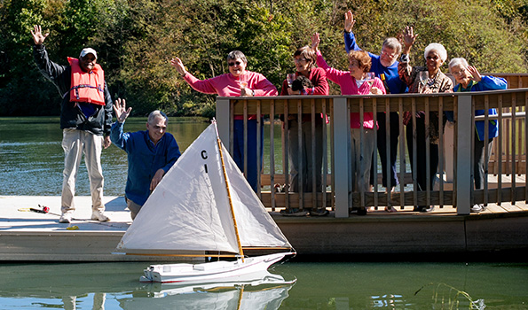 residents on lake with sailboat