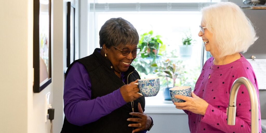 women sharing a cup of tea and laughing