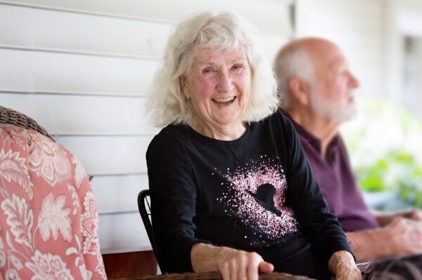 resident smiling on porch.