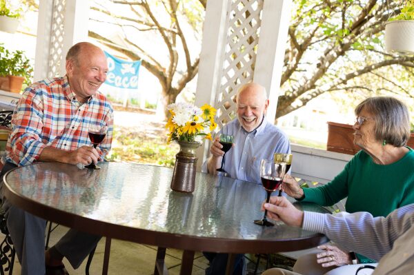 Residents sitting around table drinking wine